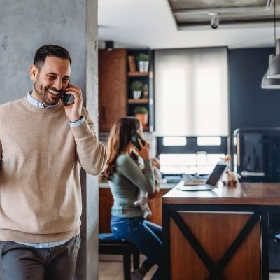 Happy caucasian man laughing during smartphone conversation.